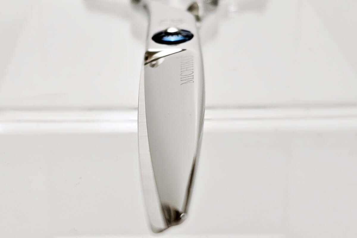 Close-up of a hair scissors blade on a white background
