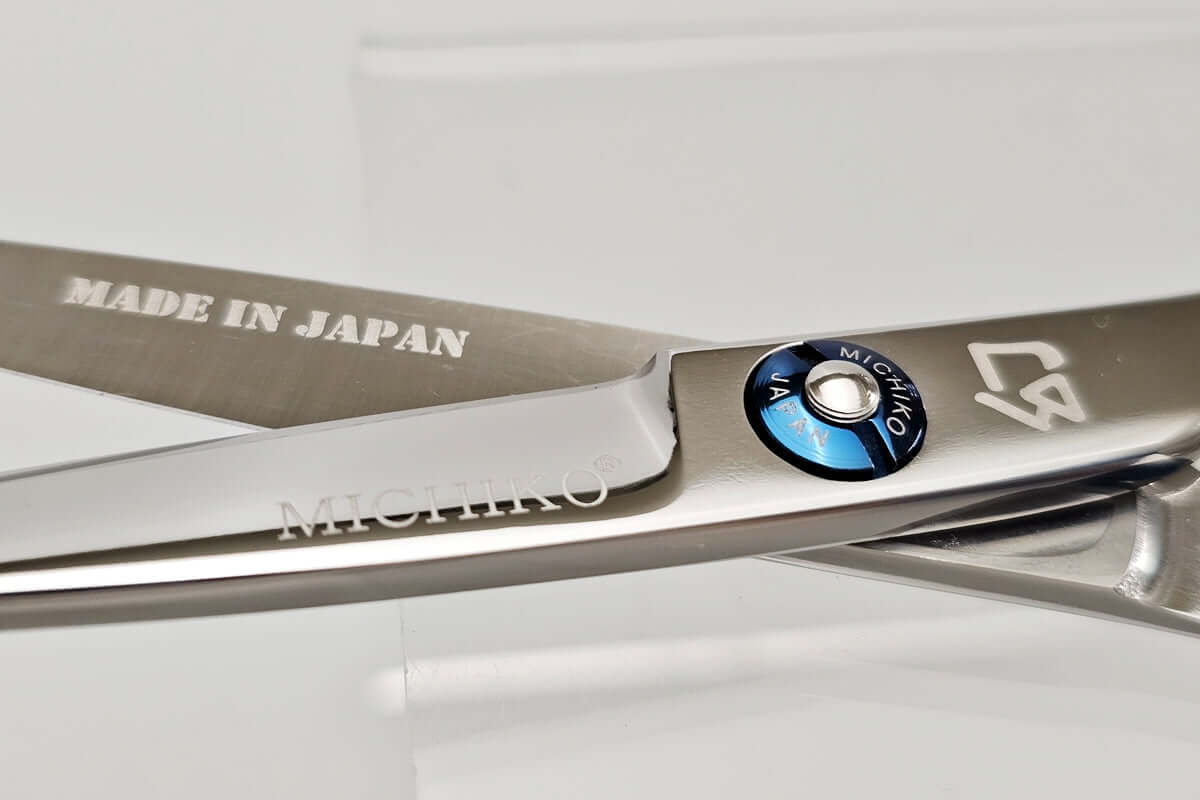 Hair cutting scissors with 'Made in Japan' and brand logos on a white background