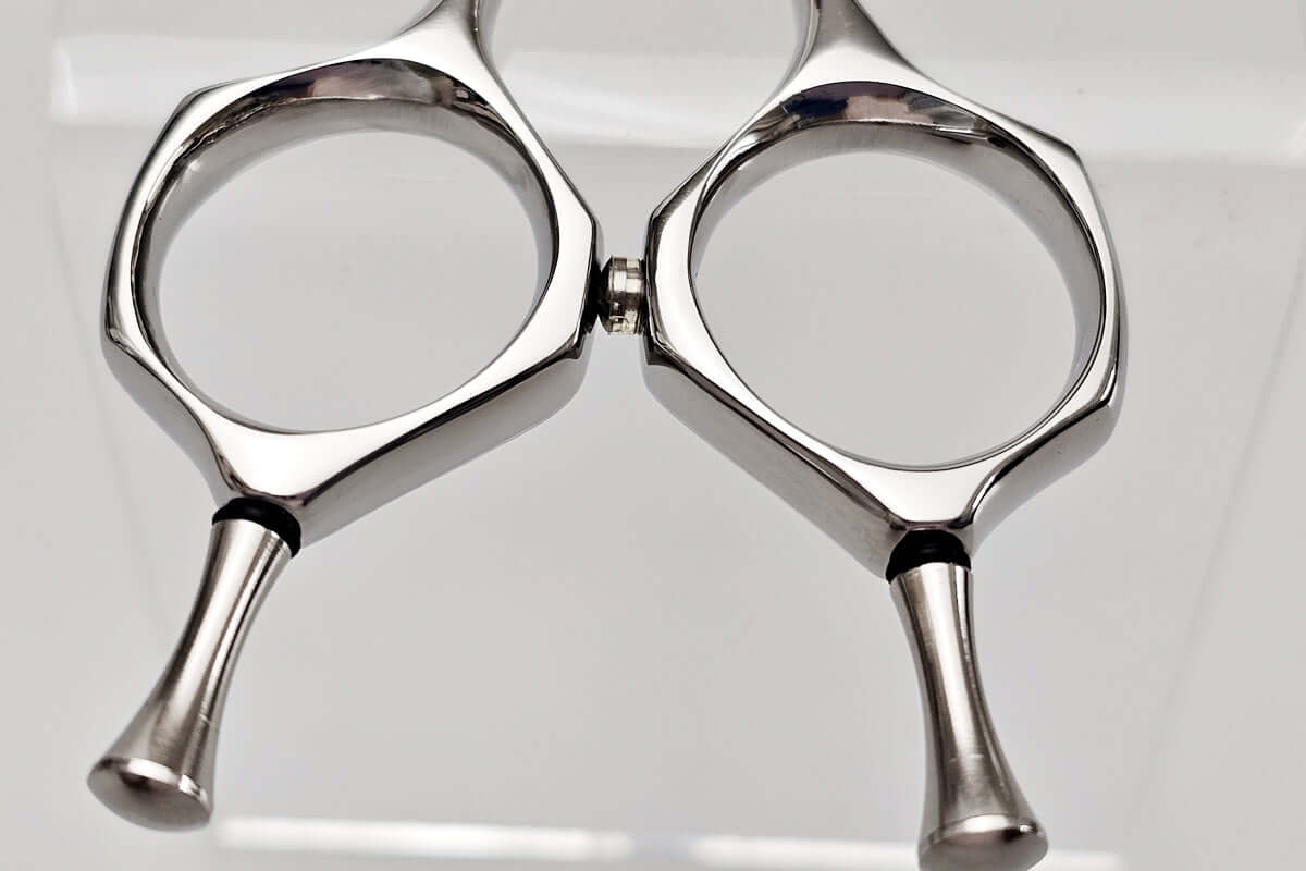 Close-up of a pair of hair scissors handle on a white background
