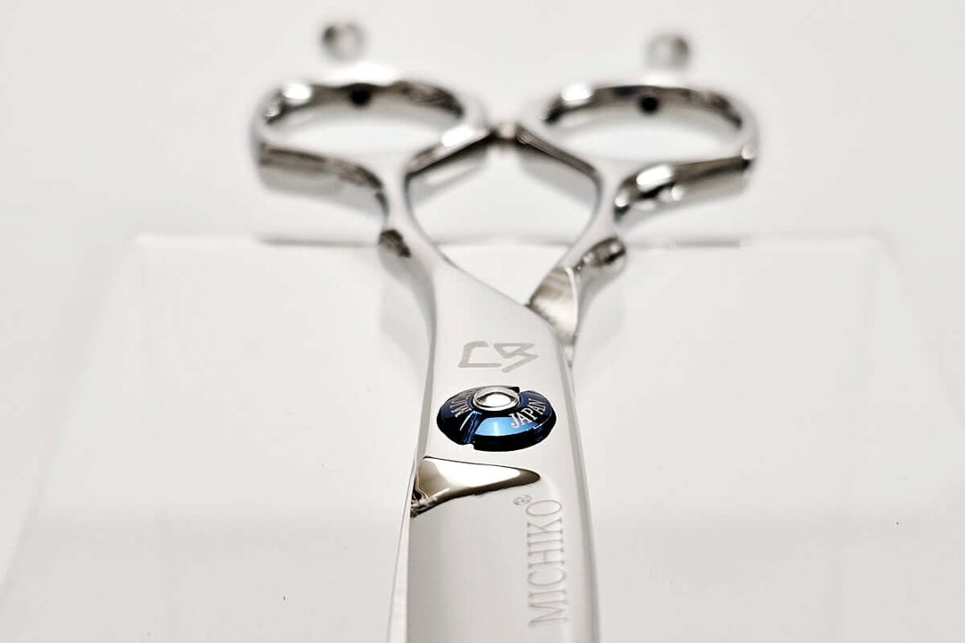 Metallic hair scissors with brand logo on a white background