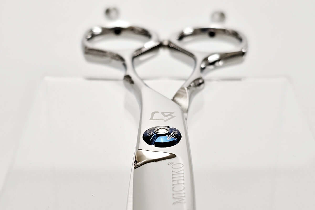 Metallic hair scissors with brand logo on a white background
