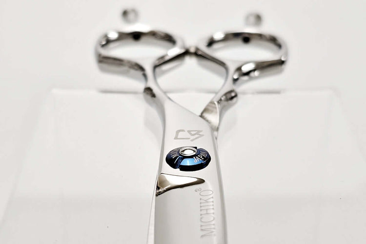 Metallic hair scissors with brand logo on a white background