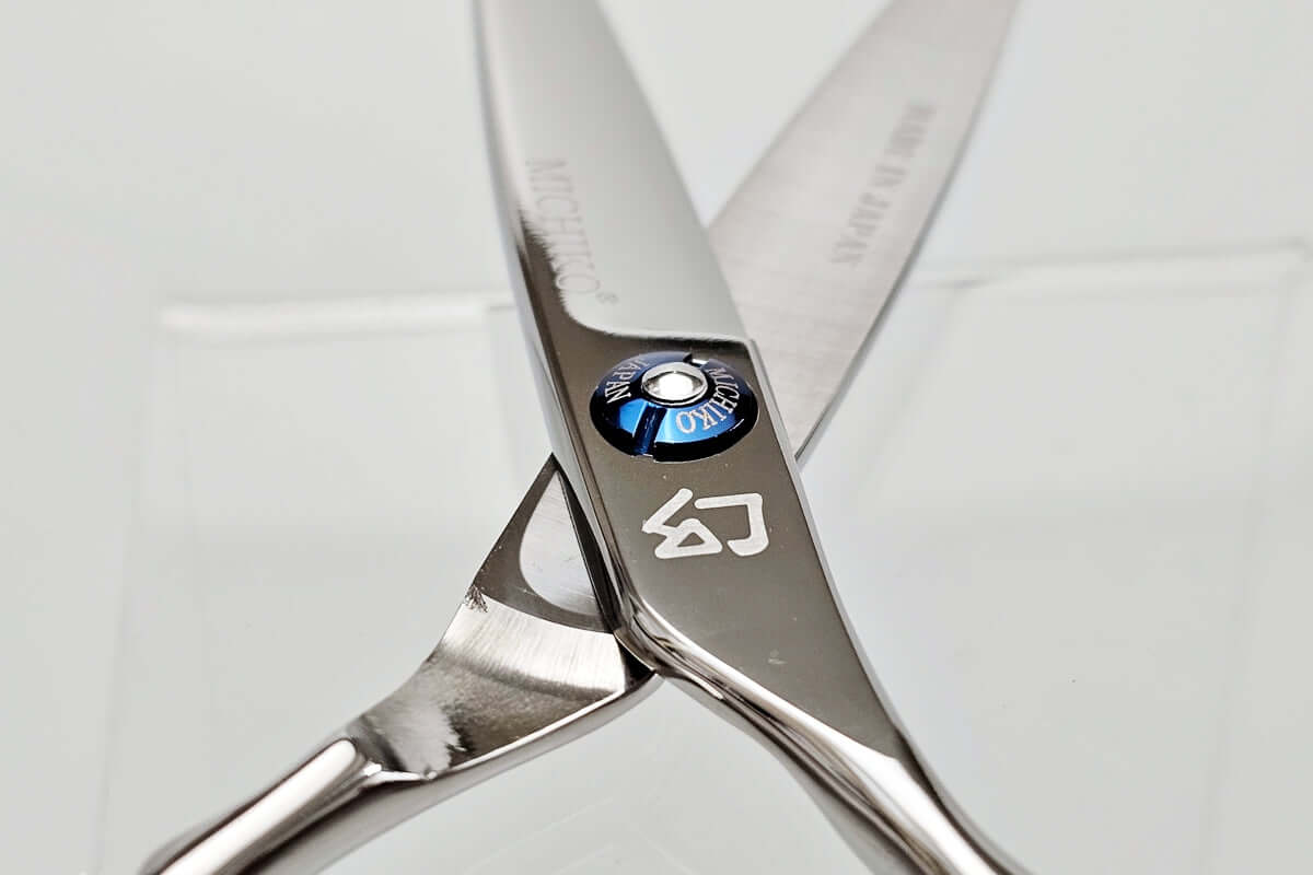 Close-up of a pair of hair scissors with a brand logo on a white background