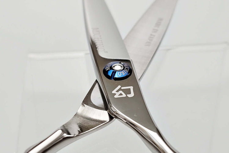 Close-up of a pair of hair scissors with a brand logo on a white background