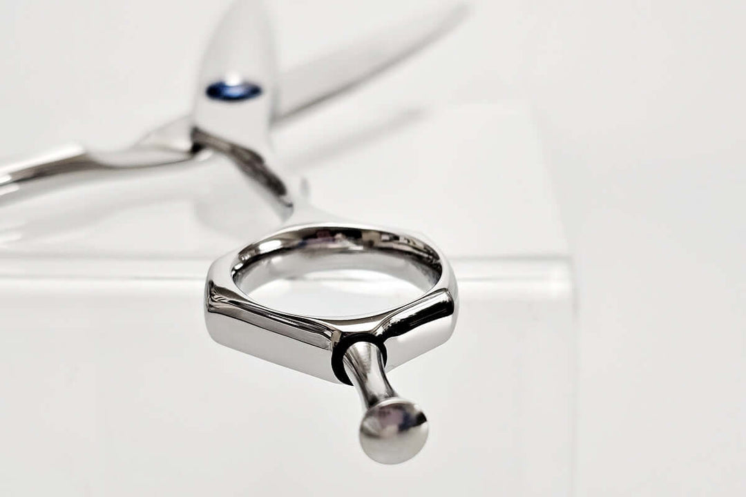Close-up of hair scissors finger ring with a unique design on a white background