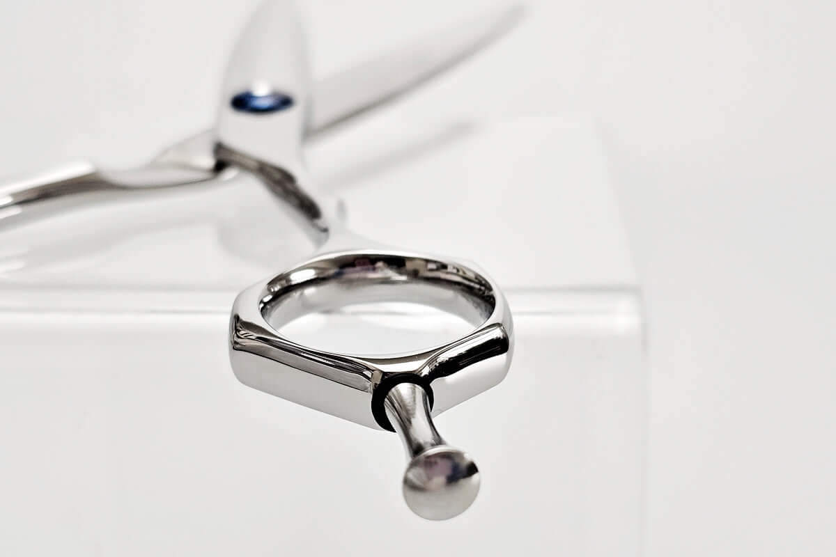 Close-up of hair scissors finger ring with a unique design on a white background