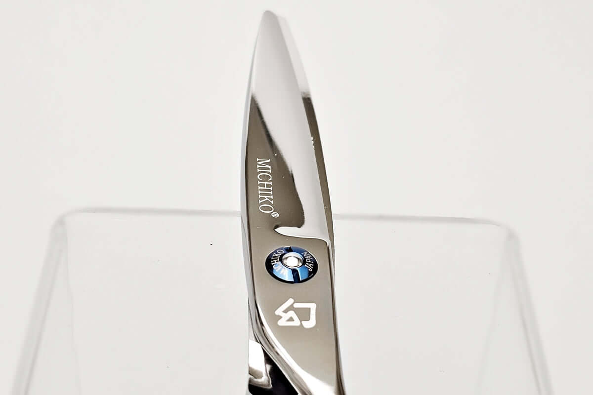 Close-up of hair scissors blade with 'Michiko' branding on a white background