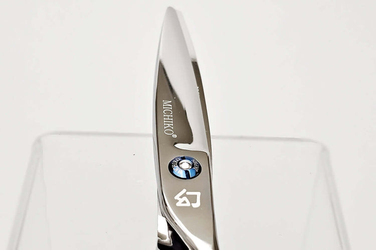 Close-up of hair scissors blade with 'Michiko' branding on a white background