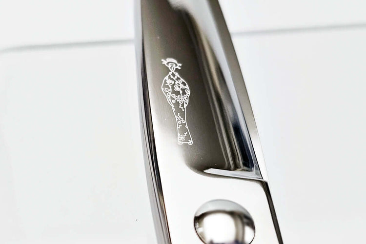 Hair scissors blade with an engraved MICHIKO lady logo design on a white background