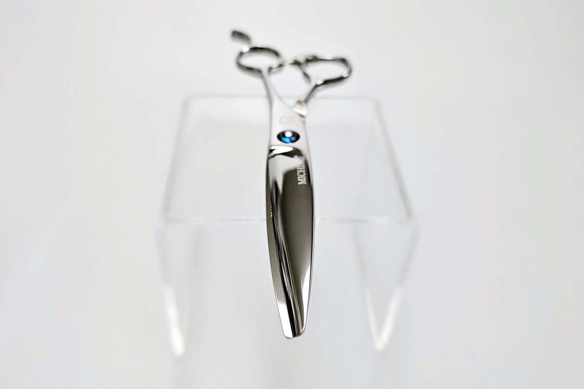 Hair scissors with a blue screw on a white background