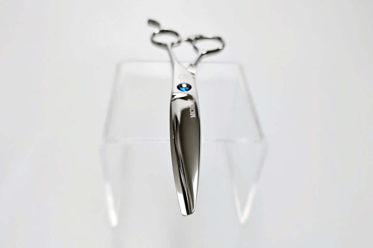 Hair scissors with a blue screw on a white background
