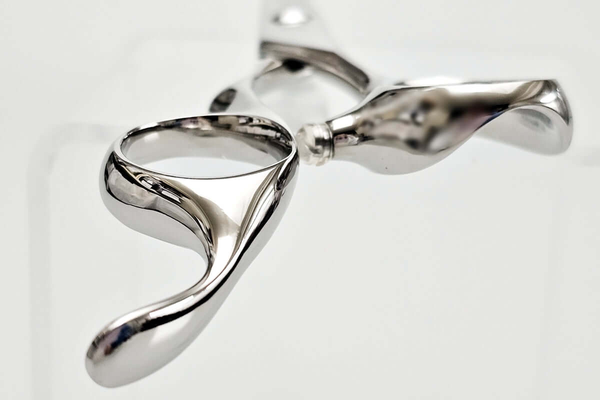 Close-up of hair scissors handle on a light gray background
