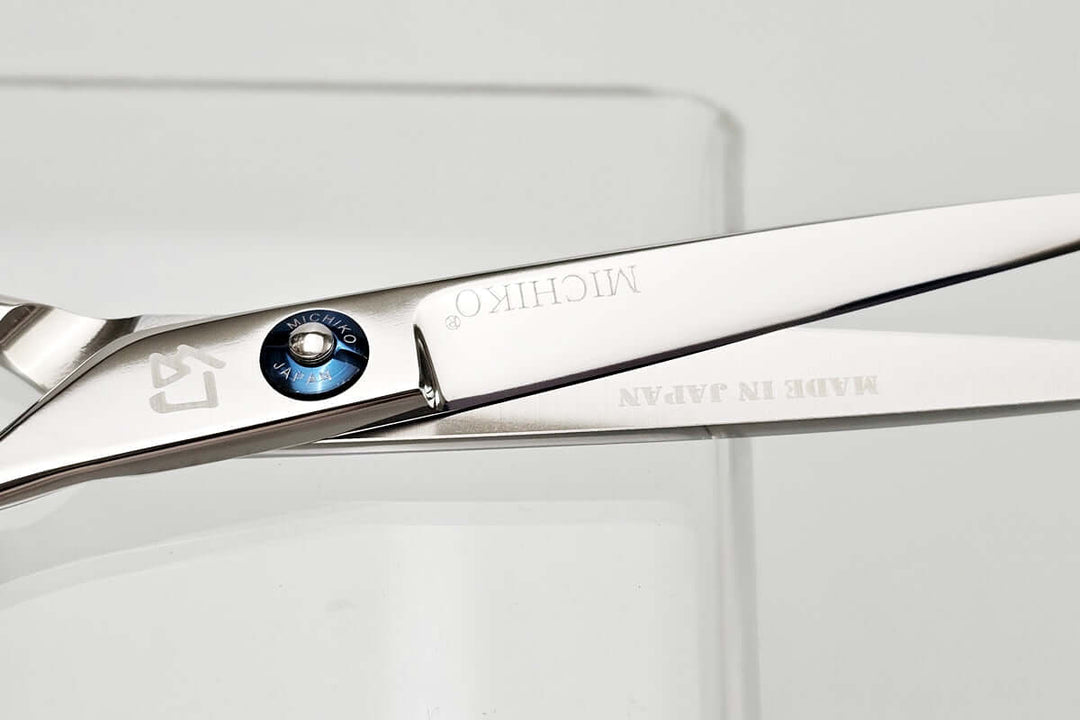 Close-up of a pair of hair scissors with Michiko brand name on a white background