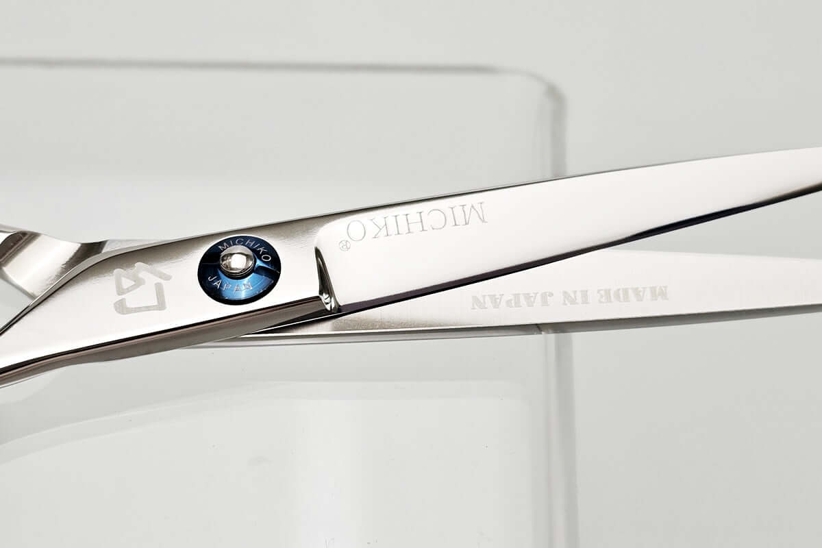 Close-up of a pair of hair scissors with Michiko brand name on a white background