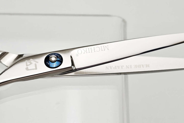 Close-up of a pair of hair scissors with Michiko brand name on a white background