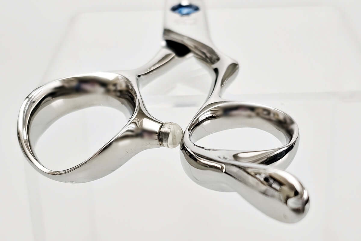Close-up of hair scissors handle on a white background