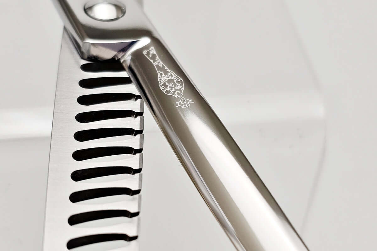 Close-up of hair texturizing shears with MICHIKO lady logo engraved on a white background