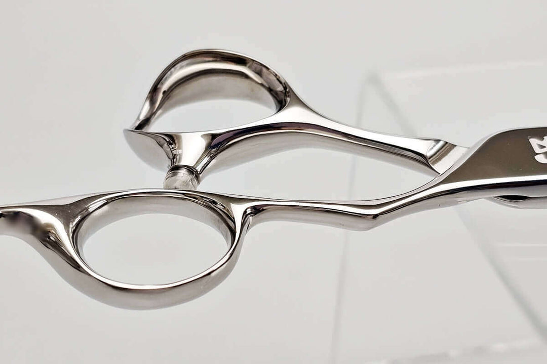 Close-up of hair scissors handle on a light gray background