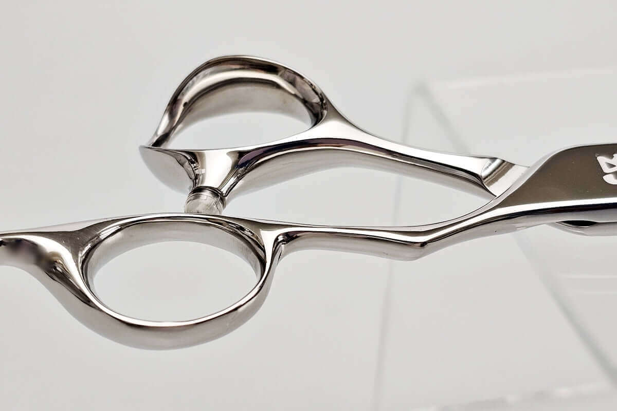 Close-up of hair scissors handle on a light gray background