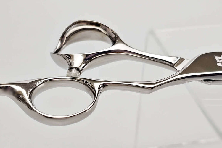Close-up of hair scissors handle on a light gray background
