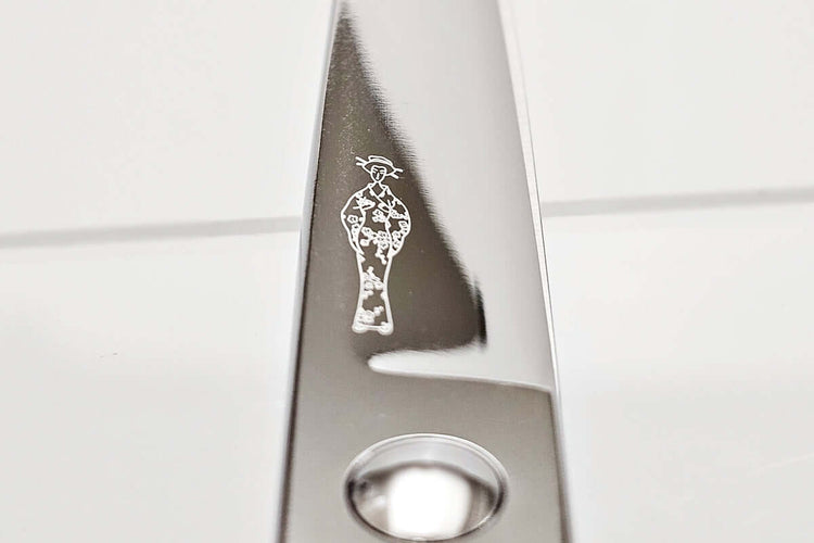 Close-up of hair scissors blade with the MICHIKO lady logo engraved on a white background