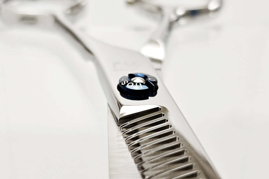 Close-up of a pair of hair thinning scissors with a brand logo on a white background
