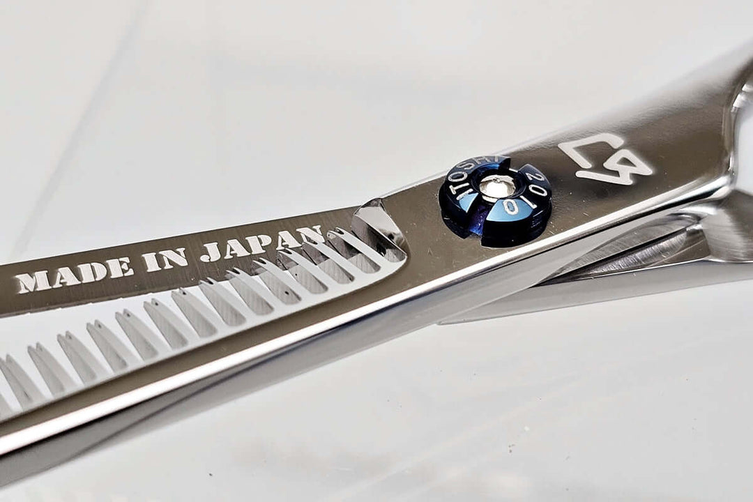 Close-up of a pair of thinning scissors with 'Made in Japan' text on a white background