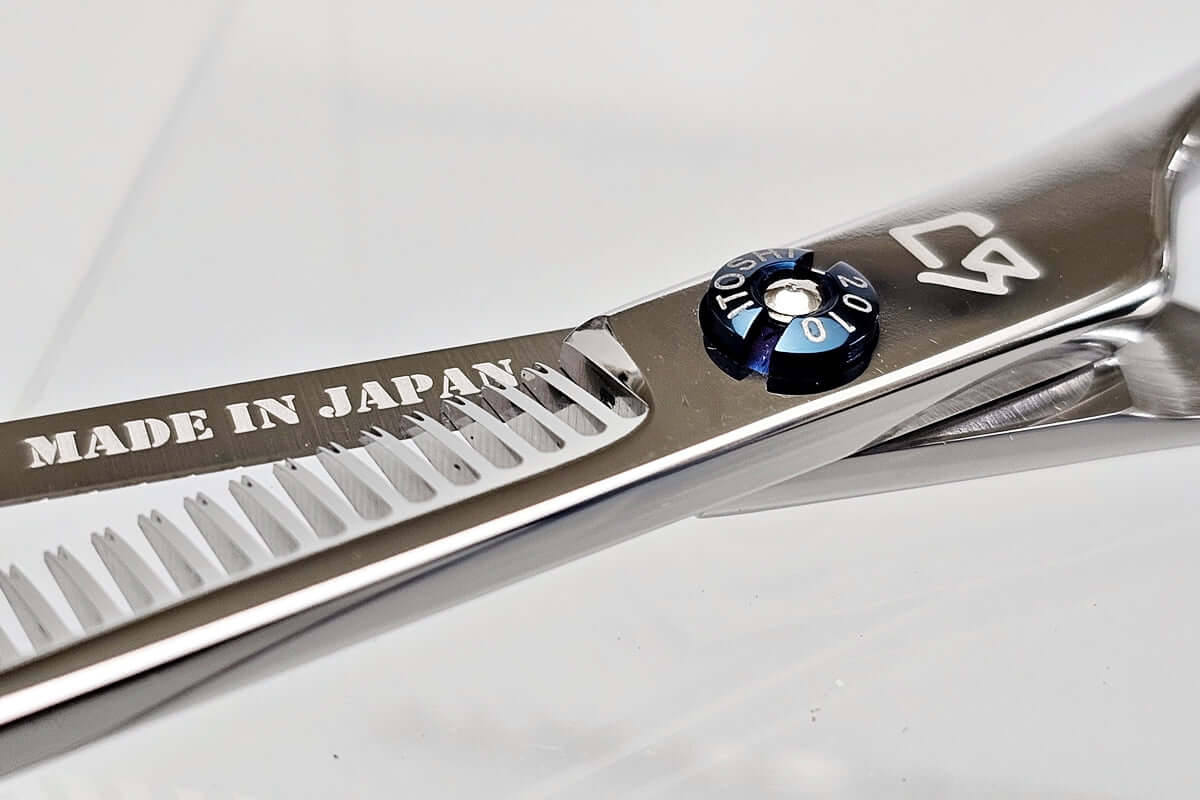 Close-up of a pair of thinning scissors with 'Made in Japan' text on a white background